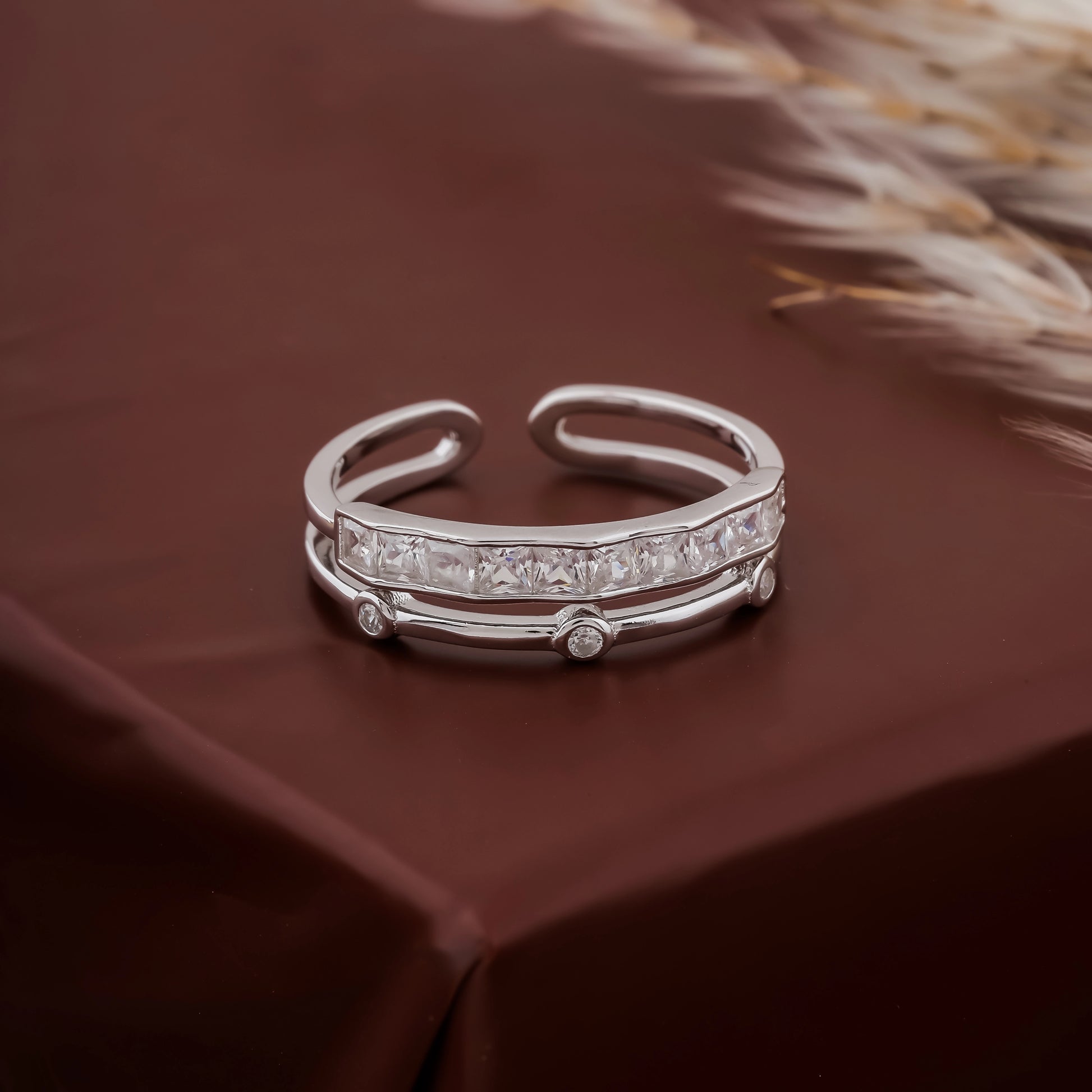 Silver ring with embedded diamonds on a brown fabric background