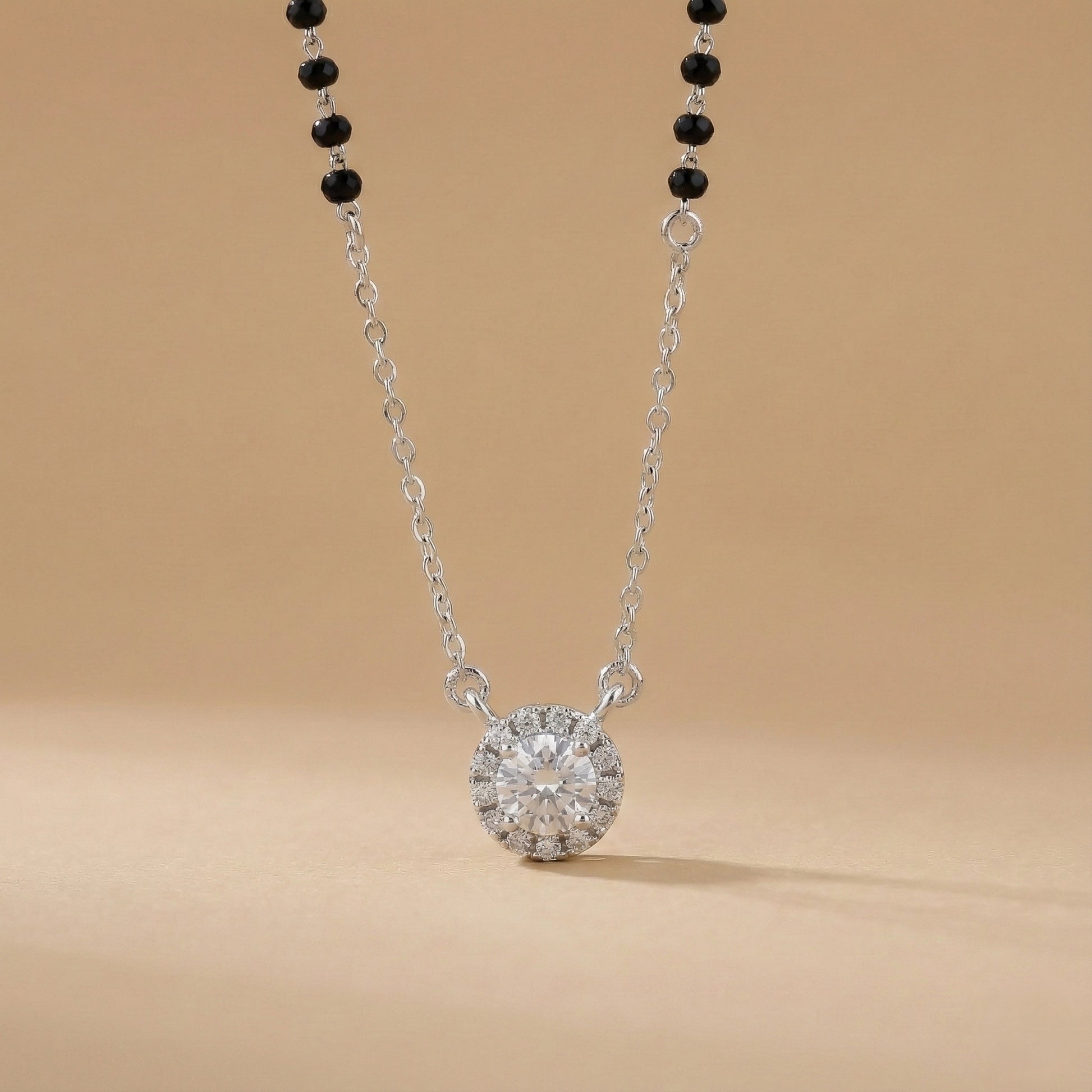Diamond necklace with black beads on a beige background