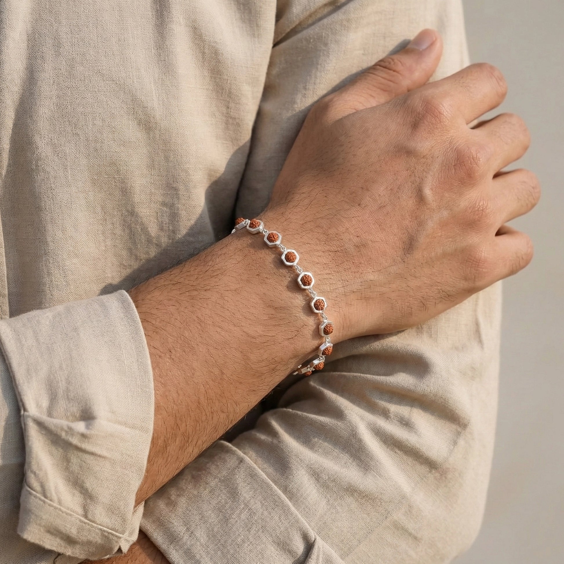 Person wearing a bracelet on a neutral background