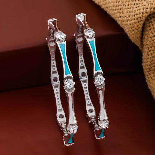 Pair of silver earrings with blue accents on a brown background