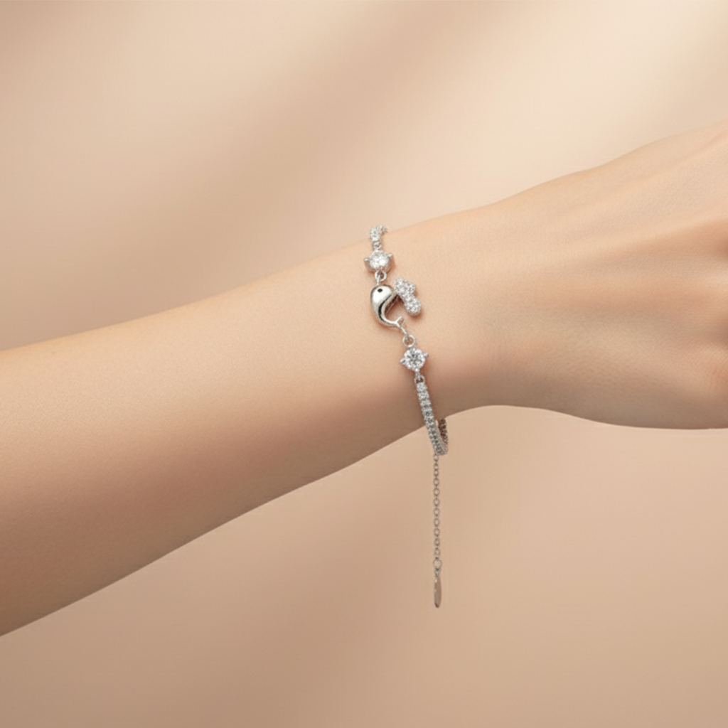 Silver bracelet with a heart and chain detail on a wrist against a beige background