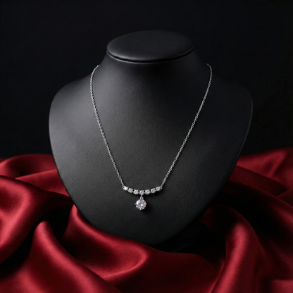 Silver necklace on a black mannequin bust with red fabric underneath