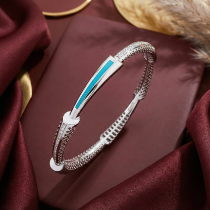 Silver bracelet with blue accent on a burgundy fabric background