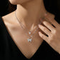 Silver butterfly necklace on a person against a dark background