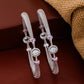 Pair of silver bangles with pink accents on a brown background