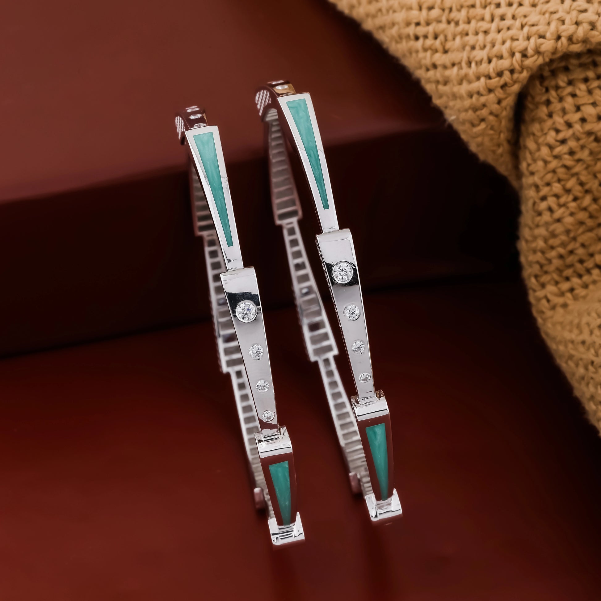 Pair of silver and turquoise cufflinks on a brown textured surface