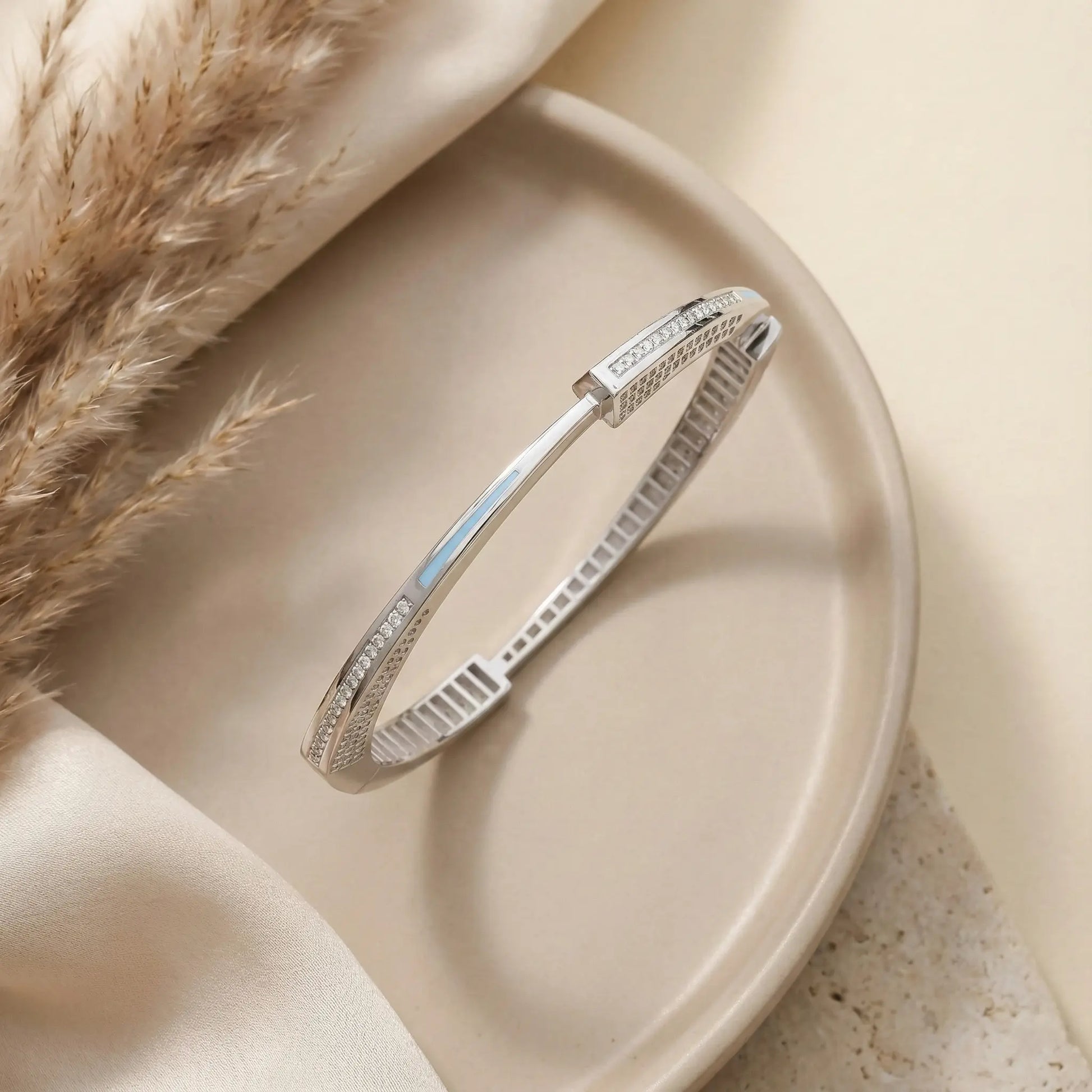 Silver bracelet on a beige plate with a soft background