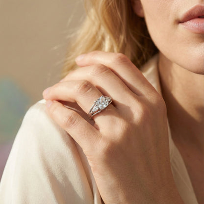 Close-up of a hand wearing a diamond ring with a blurred background