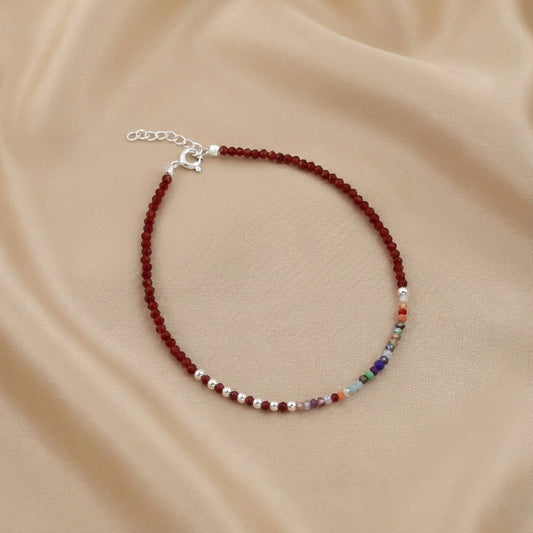 Beaded bracelet with multicolor beads on a beige fabric background