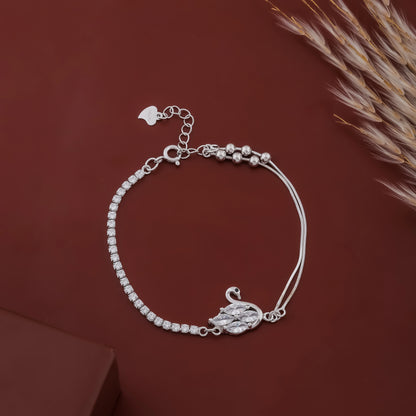 Silver bracelet with a swan charm on a brown background