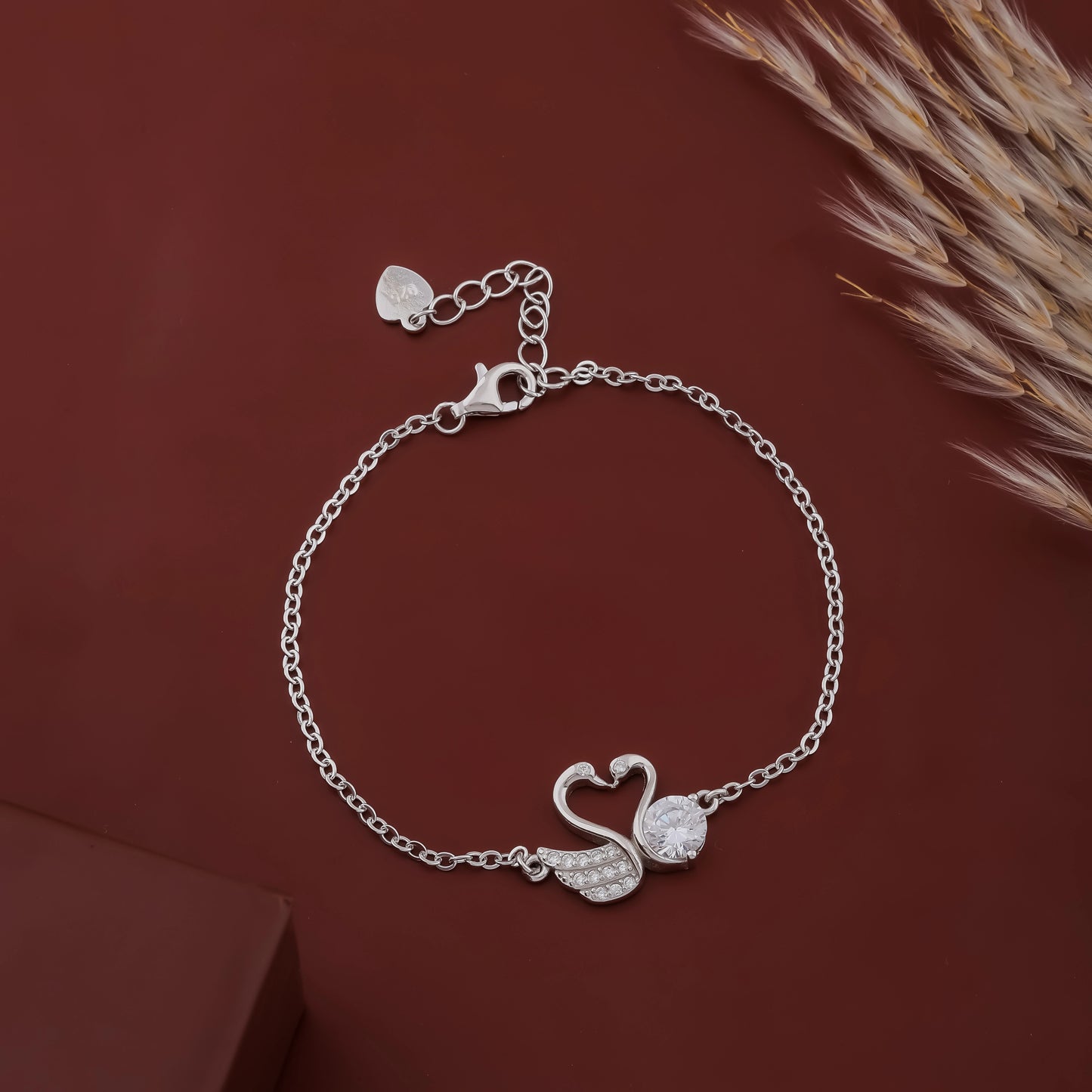 Silver bracelet with a swan design on a brown background