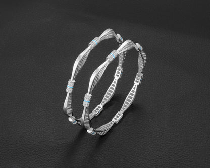 Two silver hoop earrings with turquoise stones on a dark background