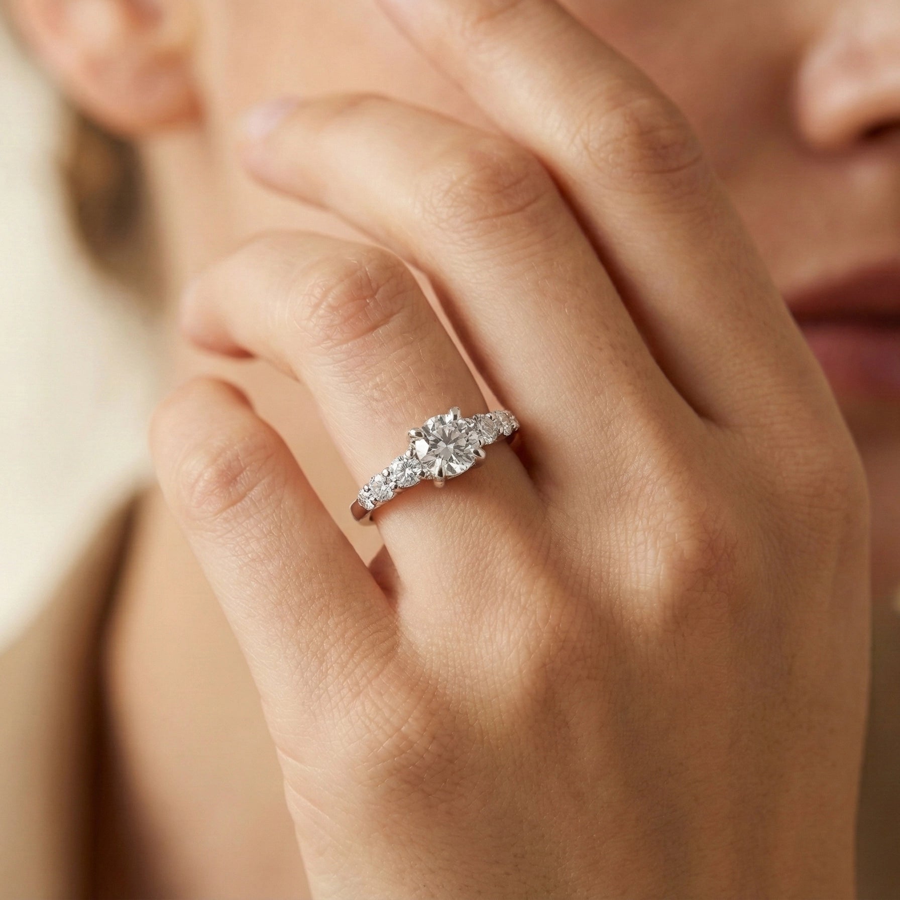 Close-up of a hand wearing a diamond ring with a blurred background