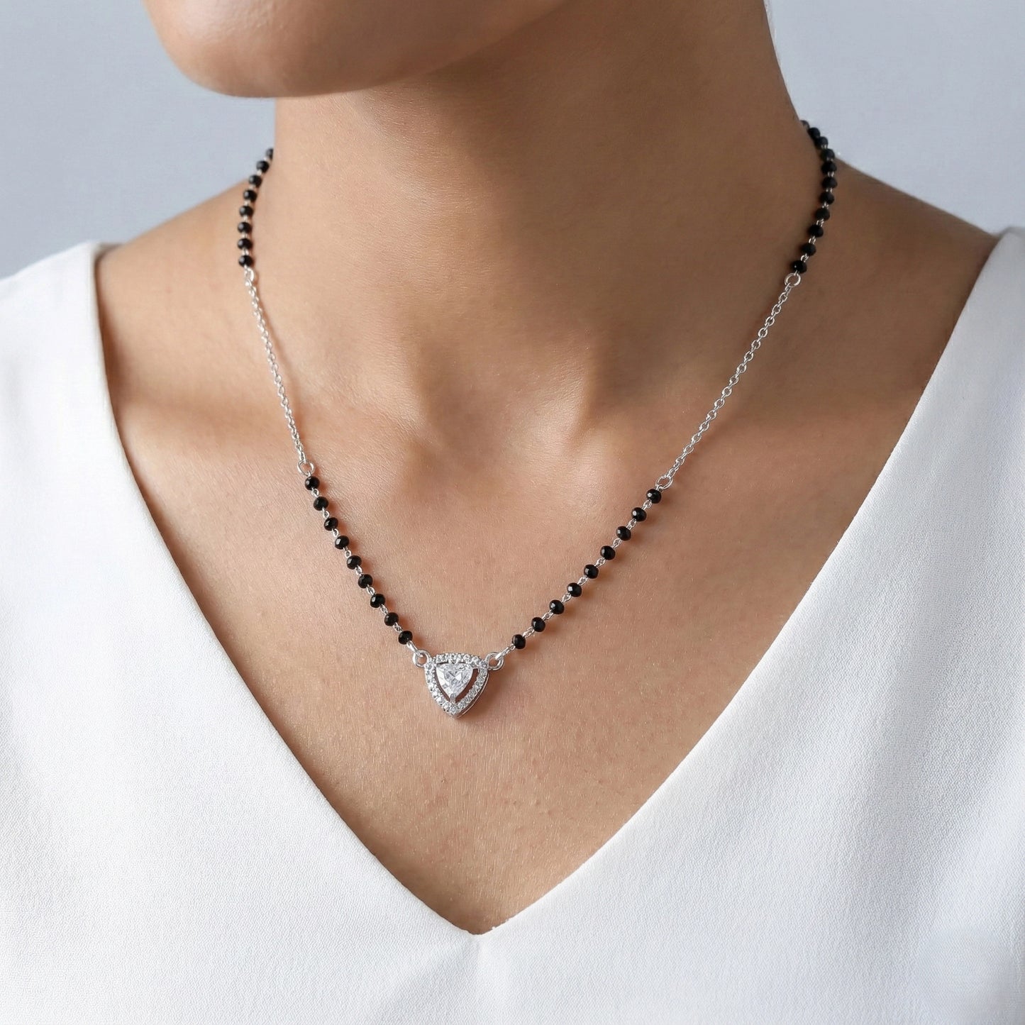 Necklace with black beads and a heart-shaped pendant on a white background