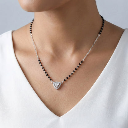 Necklace with black beads and a heart-shaped pendant on a white background
