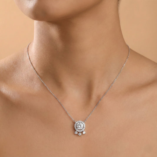 Silver necklace with a pendant on a model against a beige background