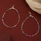 Two colorful beaded necklaces on a red background