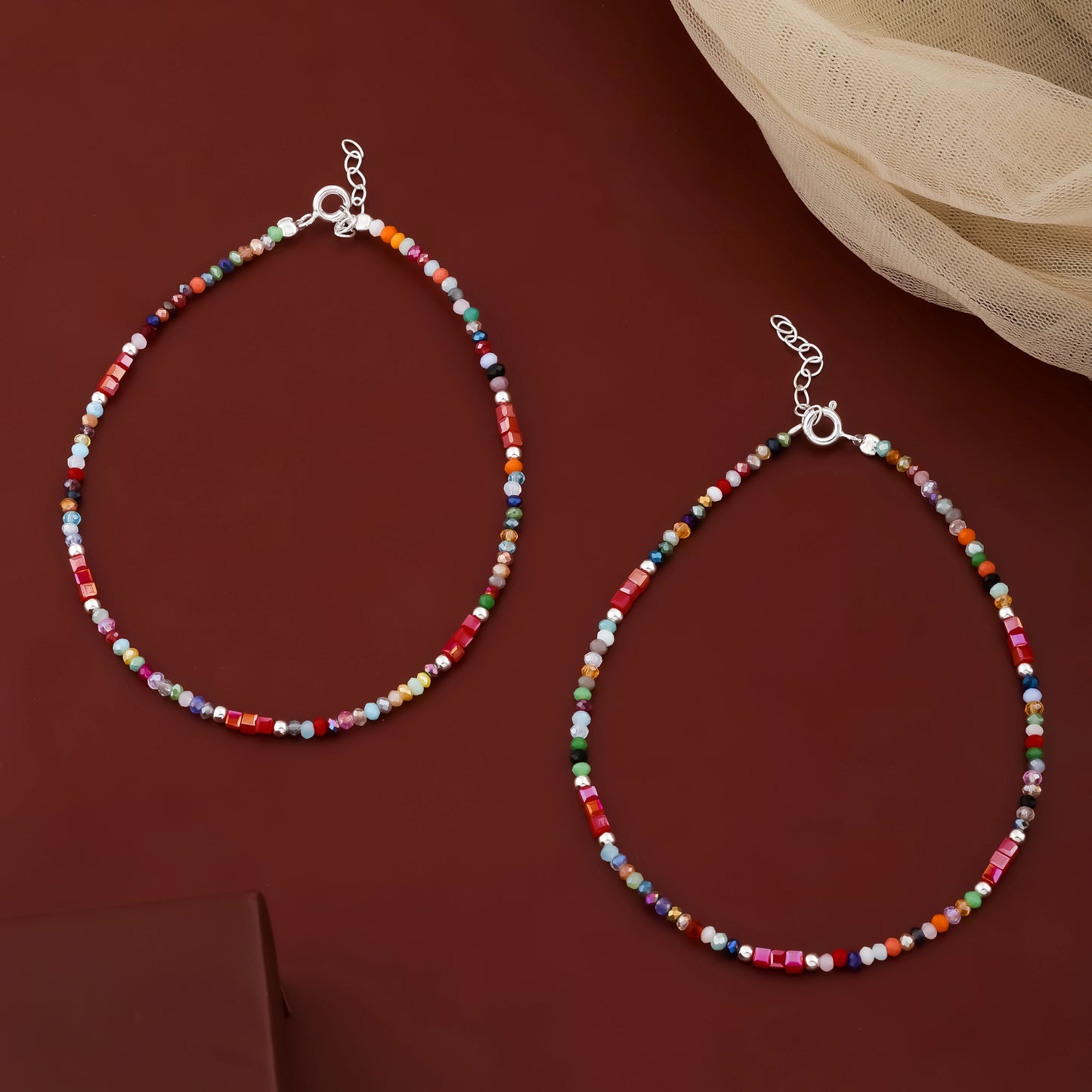 Two colorful beaded necklaces on a red background