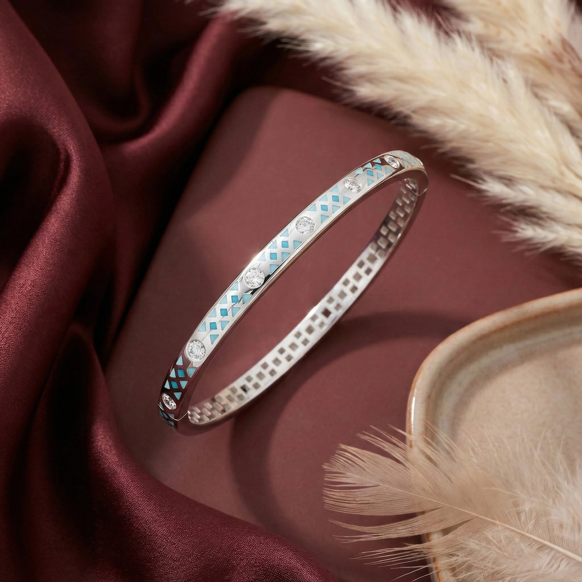 Silver bracelet with gemstones on a maroon fabric background