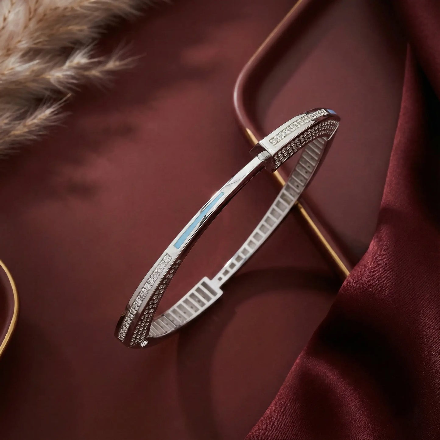 Silver bracelet with gemstones on a dark red fabric background