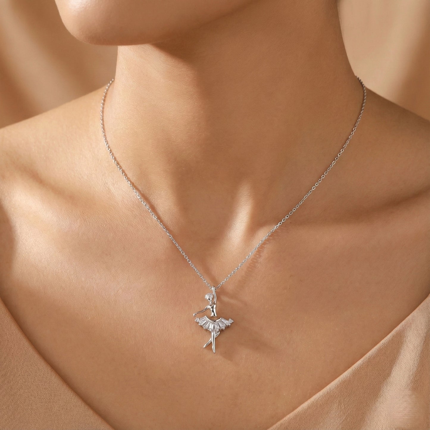 Silver necklace with a ballerina pendant on a model's neck