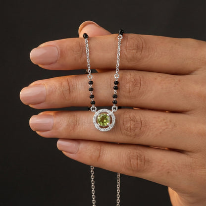 Elegant black bead mangalsutra featuring a round green gemstone in silver setting