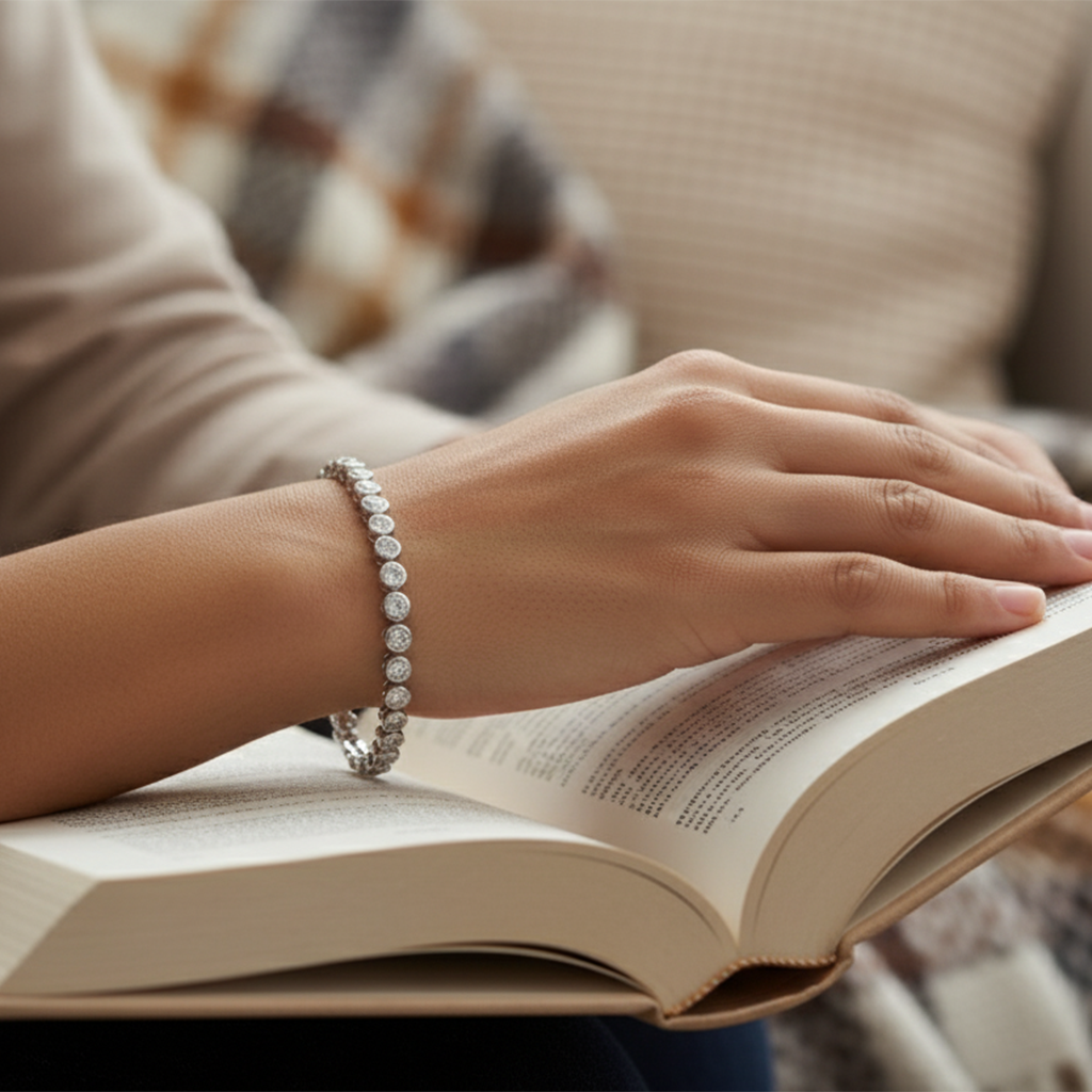 Person reading a book with a bracelet on a blurred background