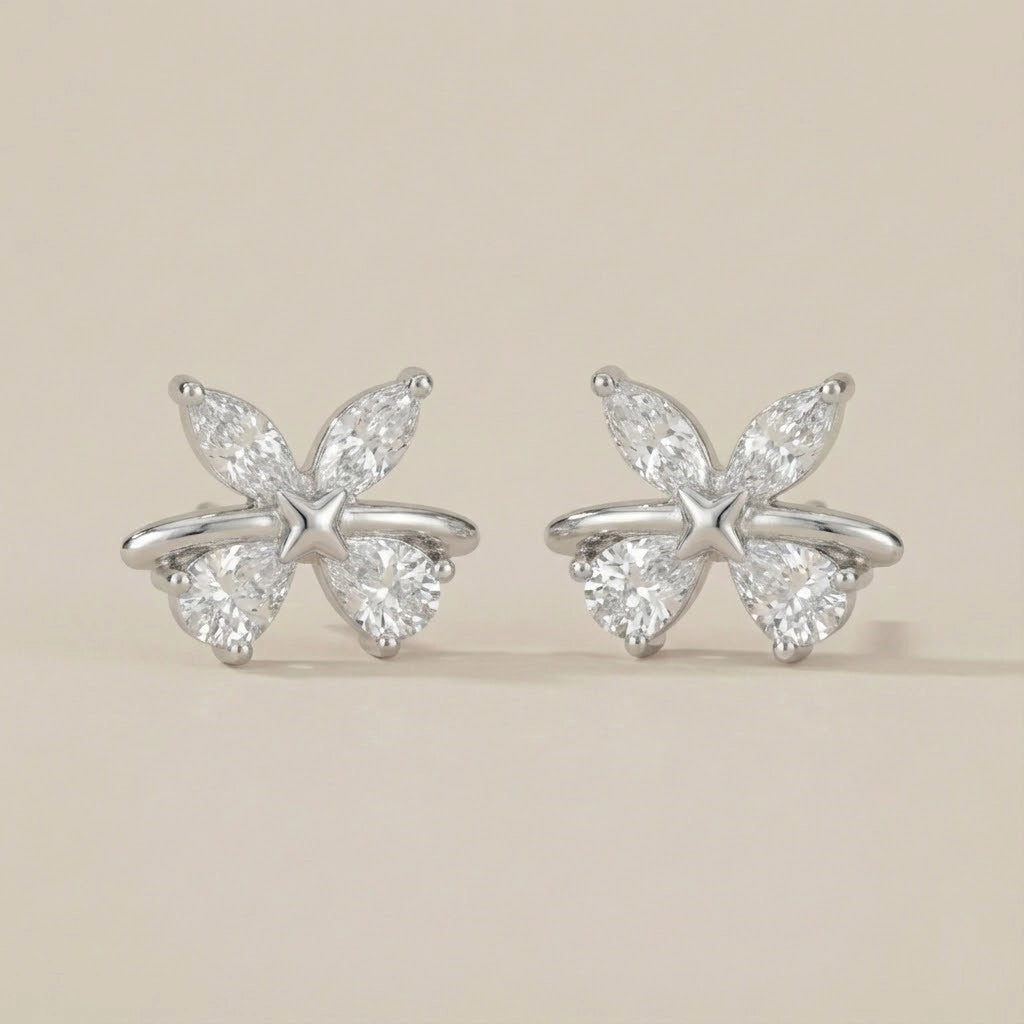 Butterfly-shaped diamond earrings on a beige background