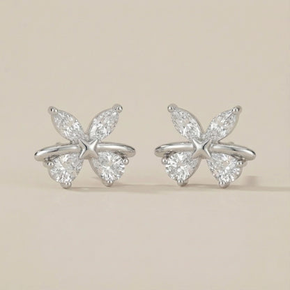 Butterfly-shaped diamond earrings on a beige background