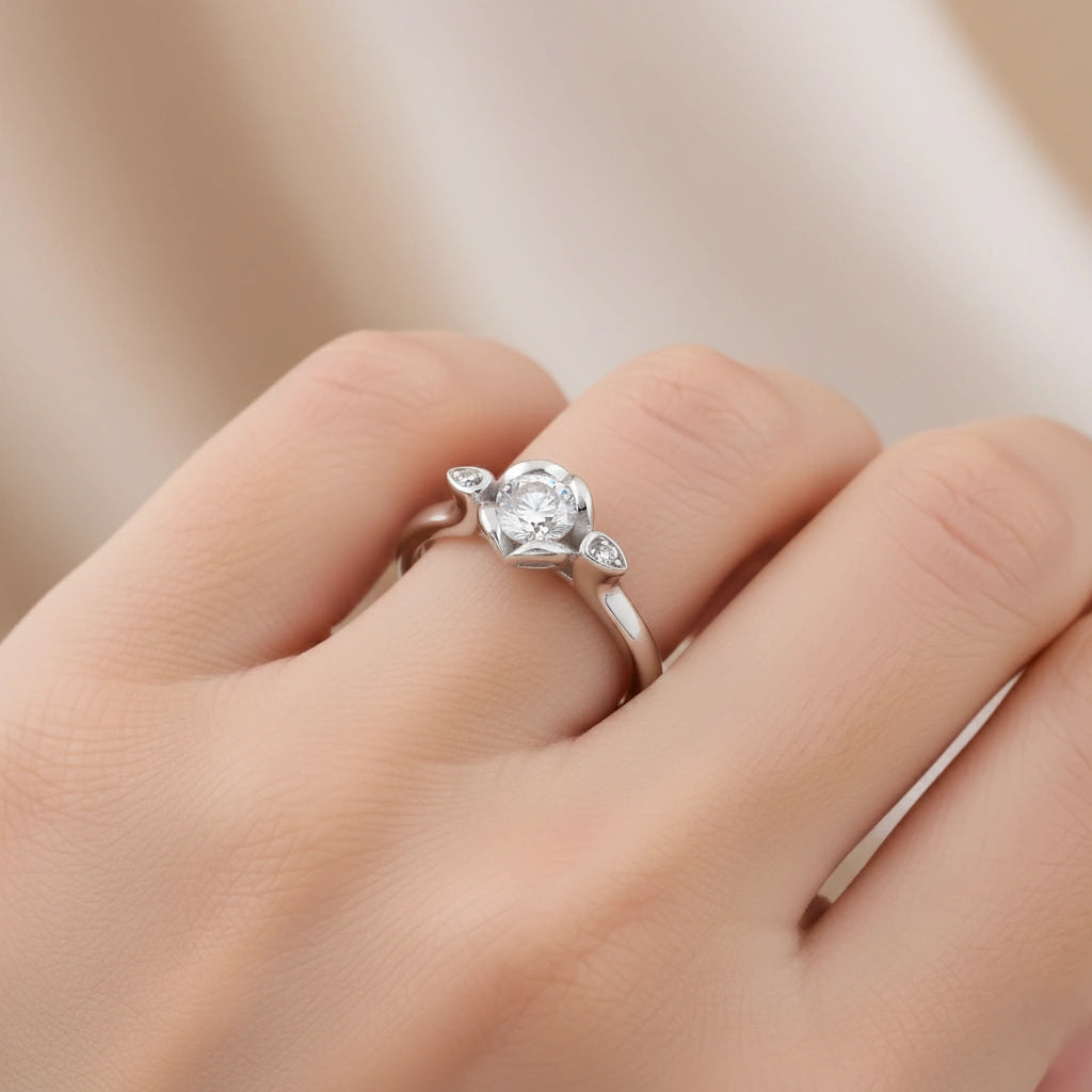 Silver ring with a diamond on a person's finger against a neutral background