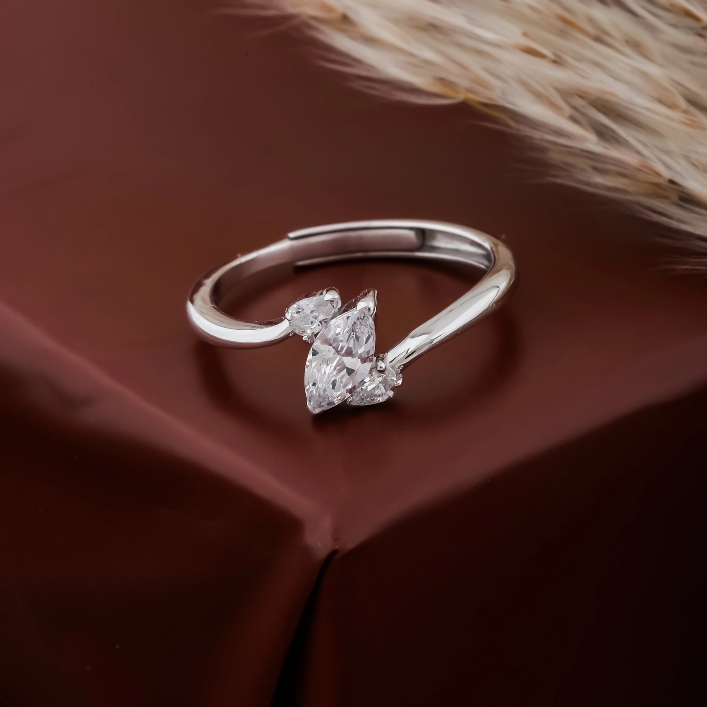 Silver ring with a heart-shaped diamond on a brown surface