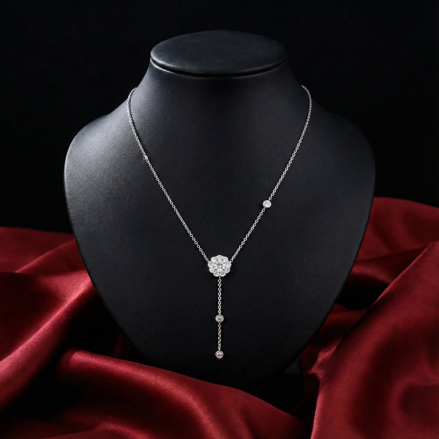 Silver necklace on a black mannequin bust with a red fabric background