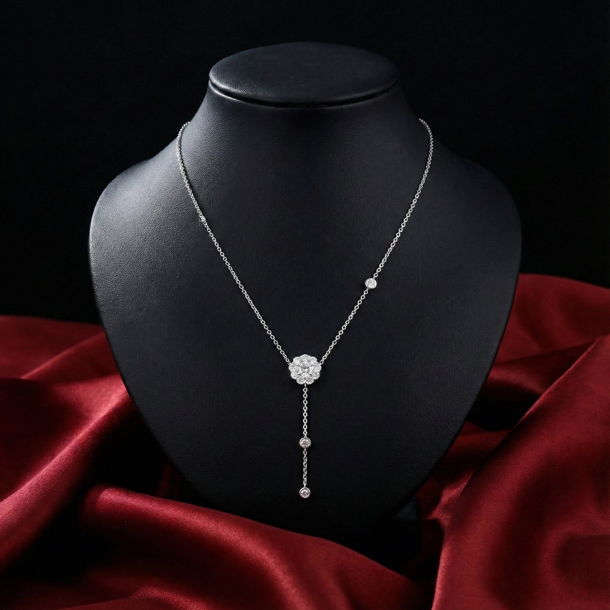 Silver necklace on a black mannequin bust with a red fabric background