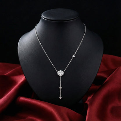 Silver necklace on a black mannequin bust with a red fabric background