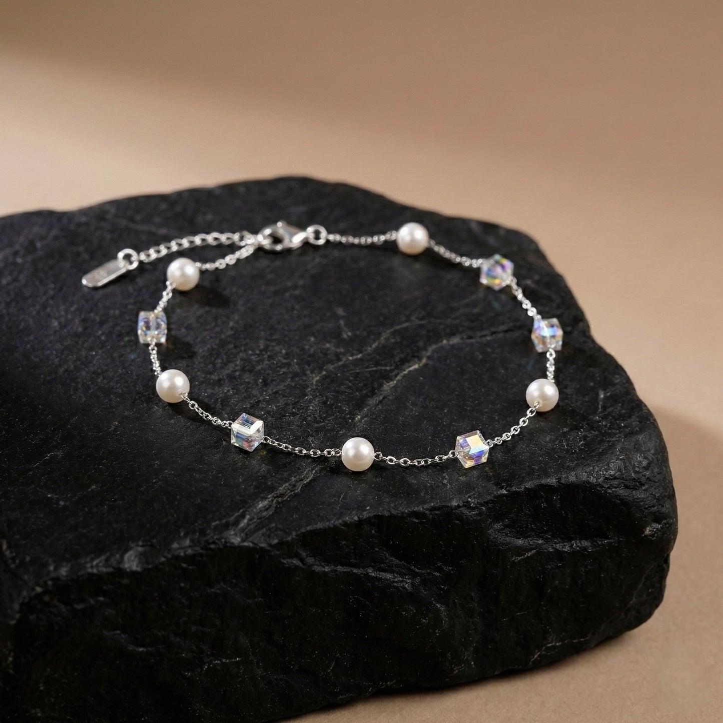 Silver bracelet with pearls and crystals on a dark stone surface