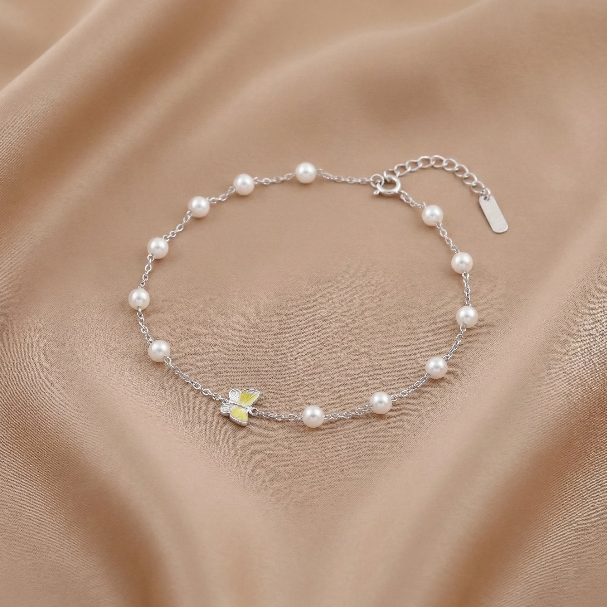 Silver chain bracelet with white pearls and butterfly charm