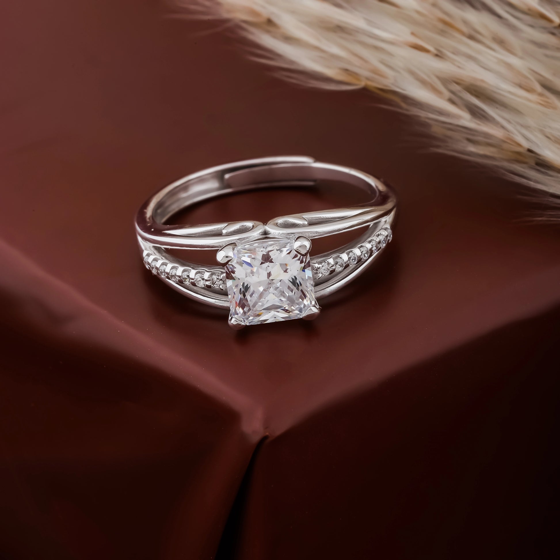 Silver ring with a large diamond on a brown fabric background