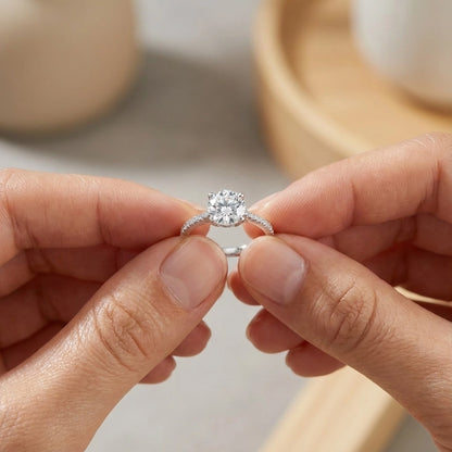 Person holding a diamond ring with a blurred background