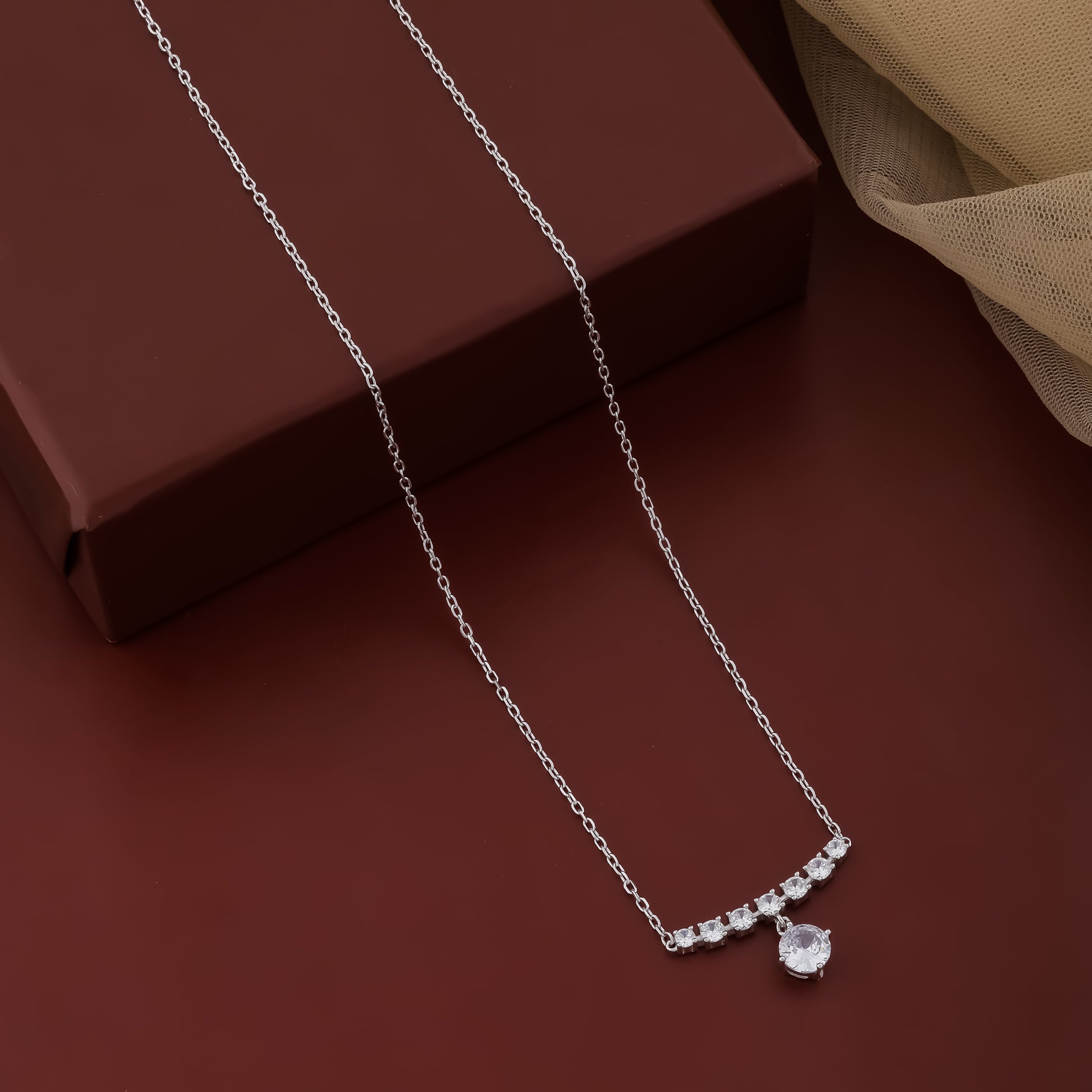 Silver necklace with a pendant on a brown surface