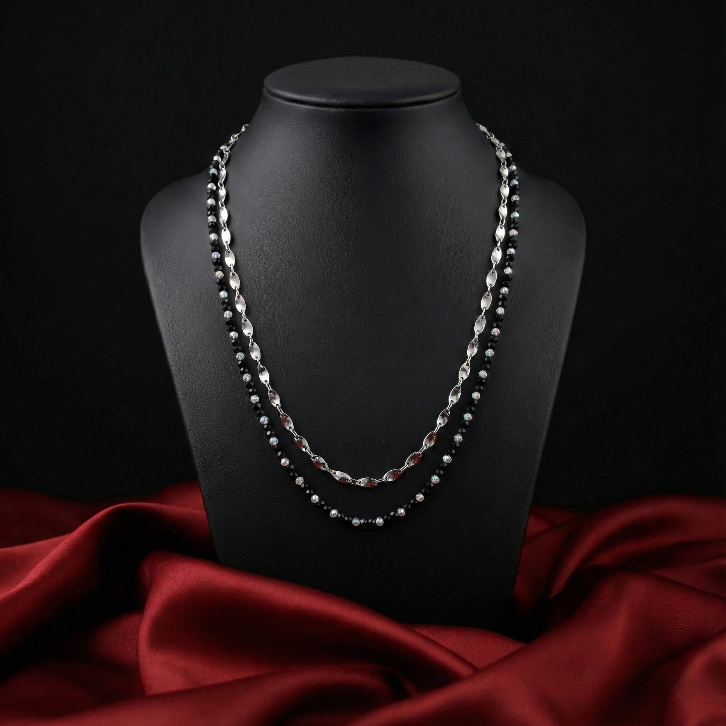 Necklace on a black mannequin bust with a red fabric background