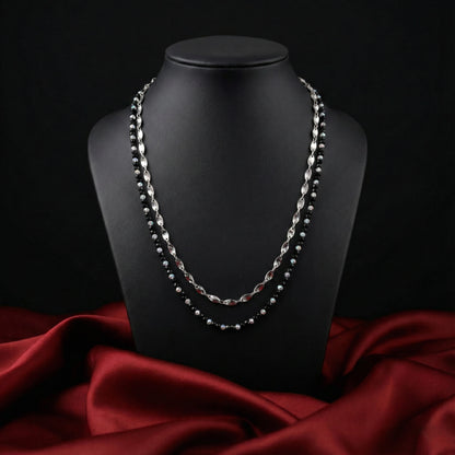Necklace on a black mannequin bust with a red fabric background
