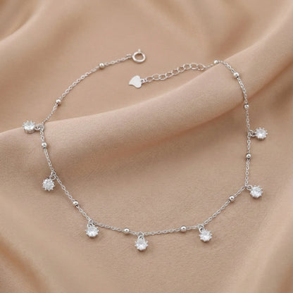 Silver bracelet with small crystals on a beige fabric background