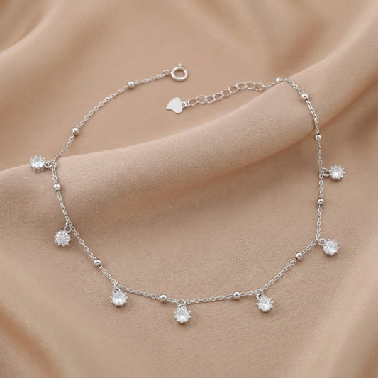 Silver bracelet with small crystals on a beige fabric background