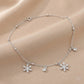 Silver bracelet with snowflake charms on a beige fabric background