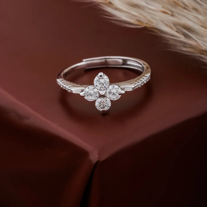 Silver ring with floral design and diamonds on a brown fabric background