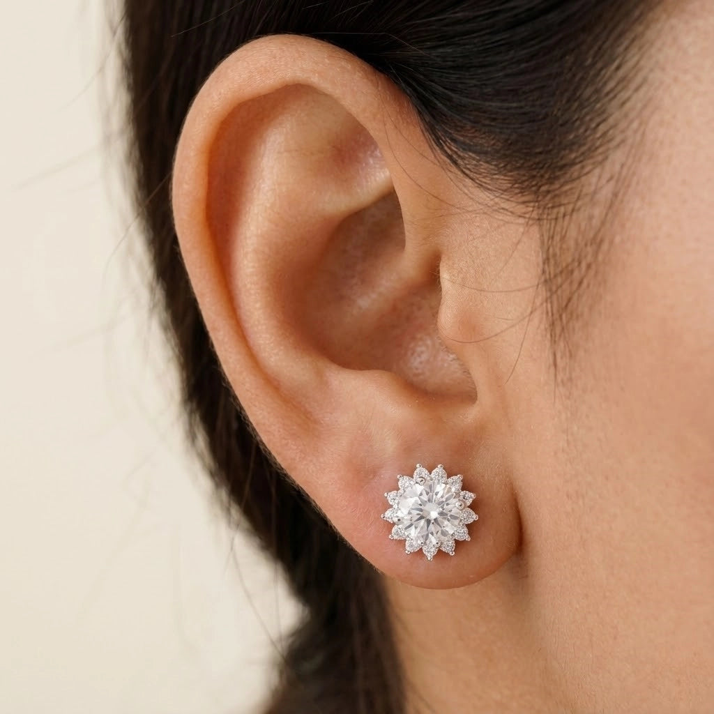 Close-up of an ear wearing a diamond stud earring with a neutral background
