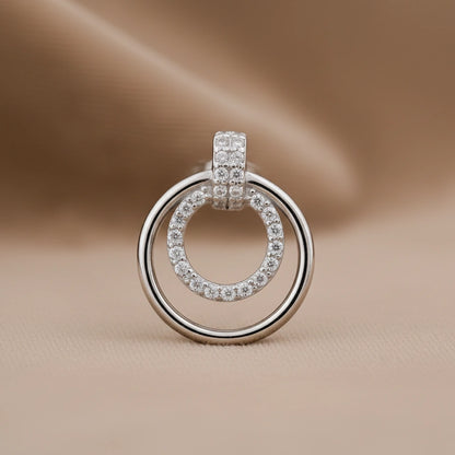 Silver ring-shaped earring with embedded stones on a beige background