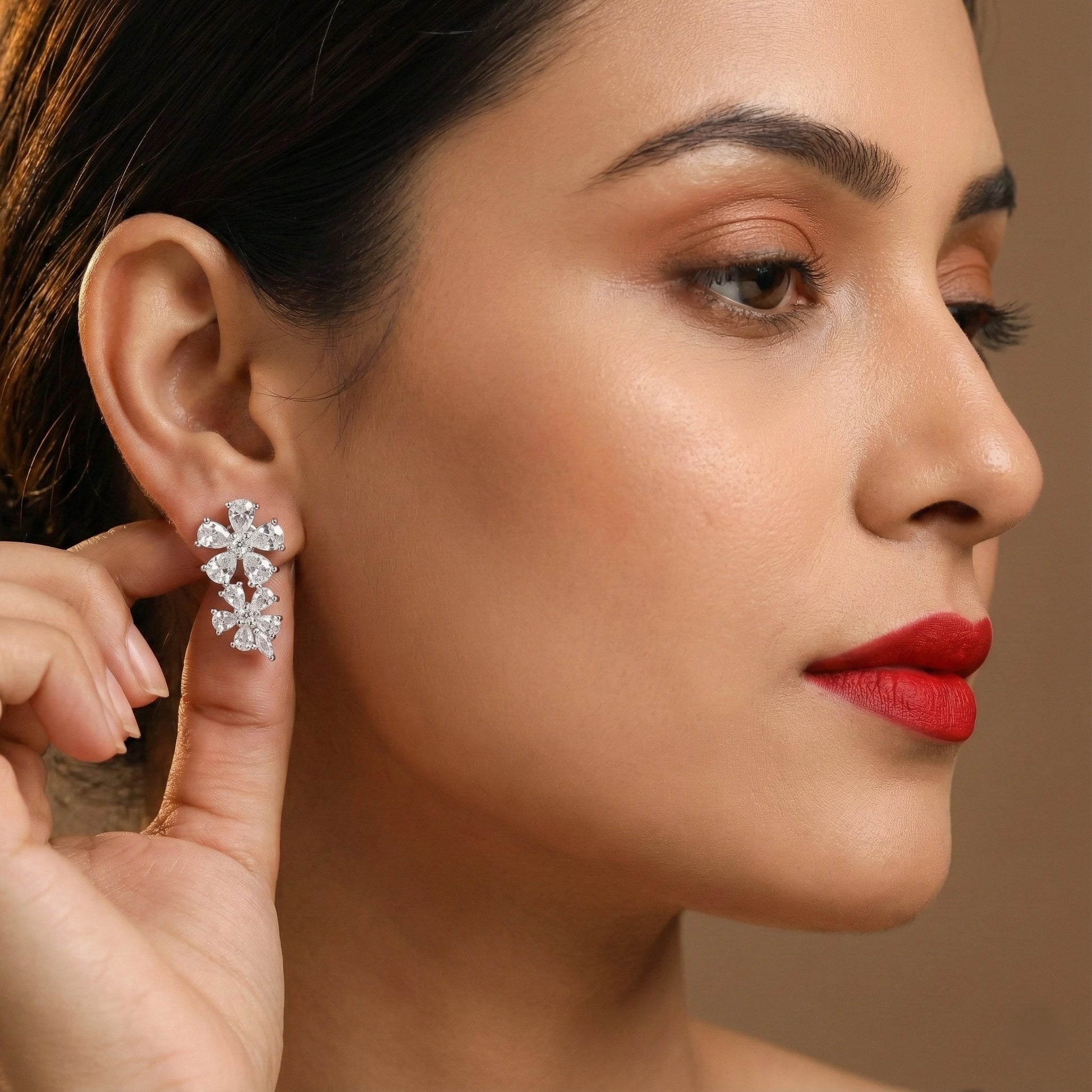 Woman wearing a diamond earring with a neutral background