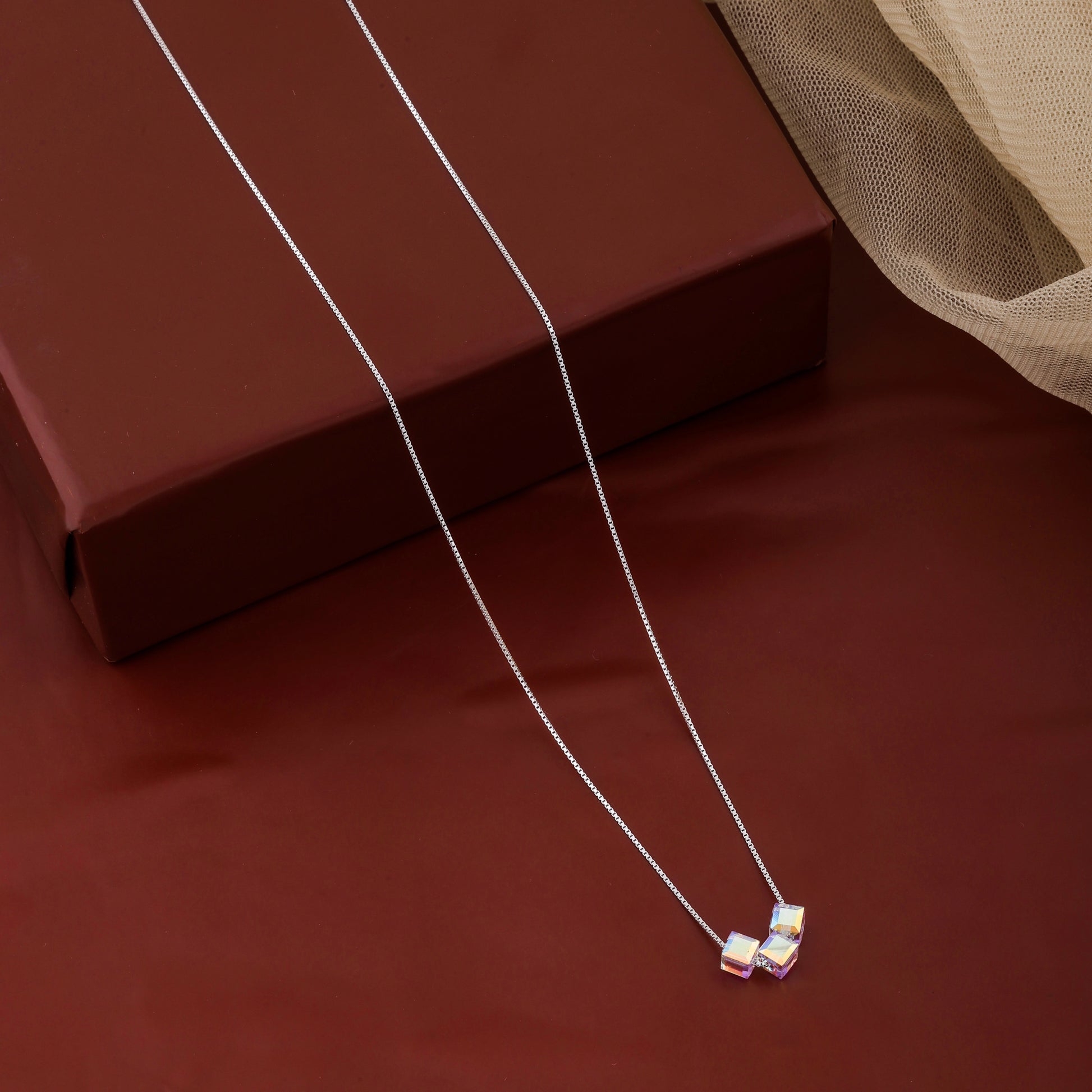 Silver necklace with a pendant on a brown surface