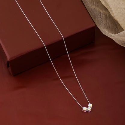 Silver necklace with a pendant on a brown surface